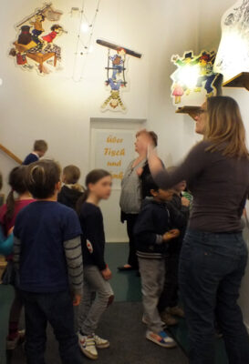 Kinder im gestalteten Foyer zur Ausstellung “Über Tisch und Bänke” bei LesArt.