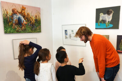 Der Künstler Sebastian Meschenmoser mit Kindern beim Besuch der Ausstellung “Kein wildes Tier!” bei LesArt.