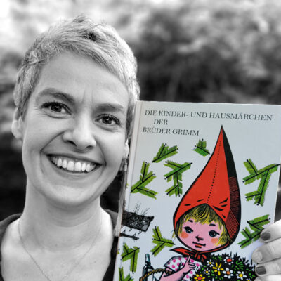 Kathleen Rappolt hält das Buch “Die Kinder- und Hausmärchen der Brüder Grimm” illustriert von Werner Klemke neben ihr Gesicht.