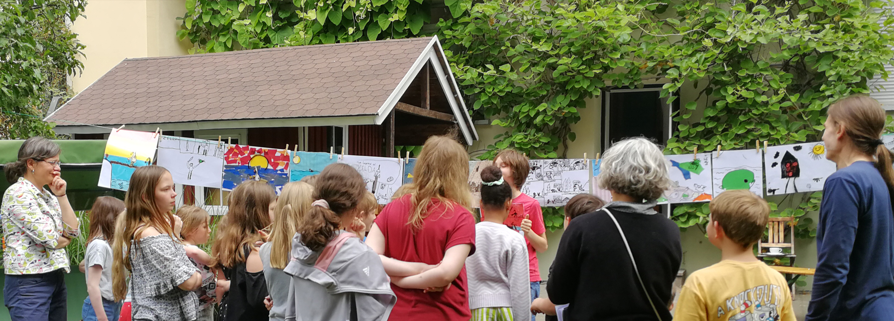 Kinder präsentieren Workshop-Ergebnisse im LesArt-Garten.