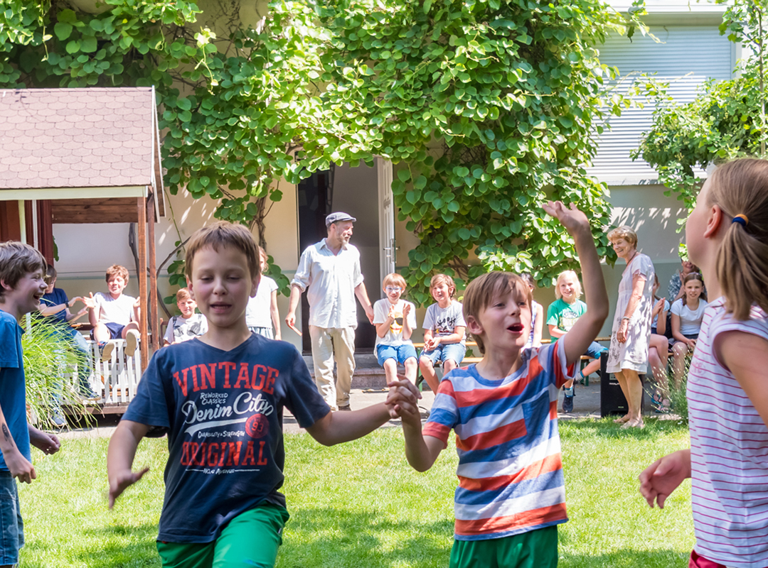 Kinder tanzend und lachend im LesArt-Garten